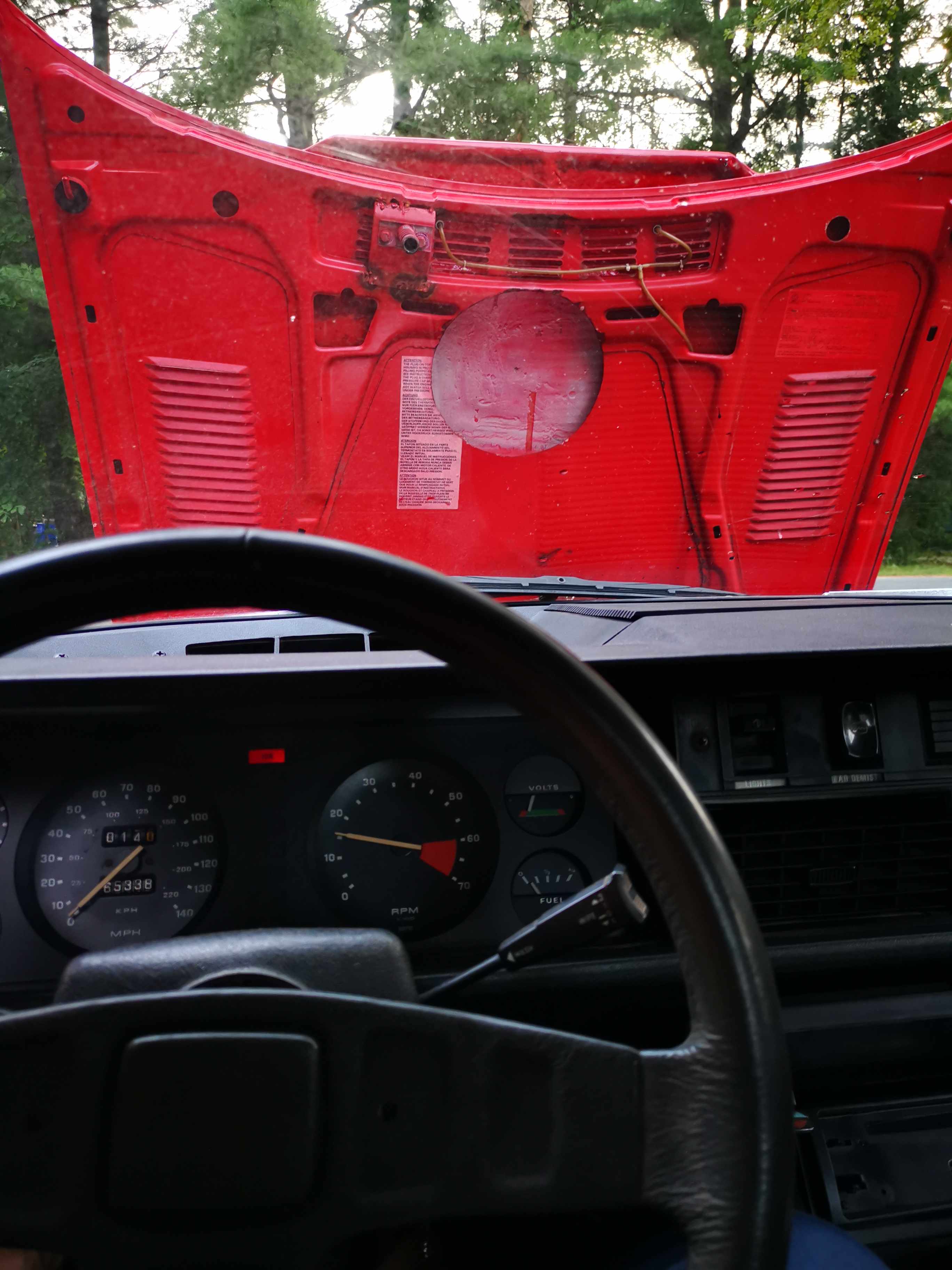 A picture from the drivers seat, with the hood open. You can see the cutout for the air filter.